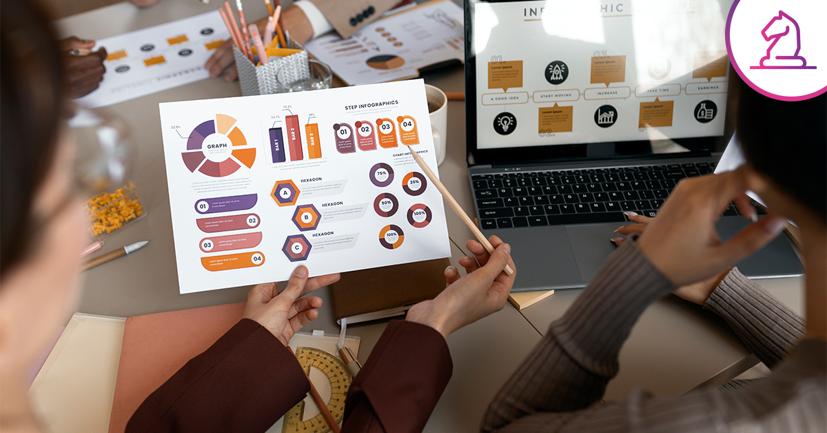 Equipo de trabajo analizando gráficos e infografías impresas junto a una laptop con reportes estratégicos en una mesa de oficina.